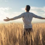 man in field decompressing from stress