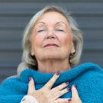 Older woman takes deep breath for relaxation