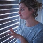 woman with agoraphobia looks out window
