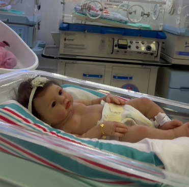 realistic baby doll is pictured in nursery and often used for therapy